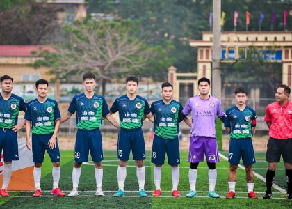 Soccer players and referees standing together on a field in Hà Nội, Vietnam.